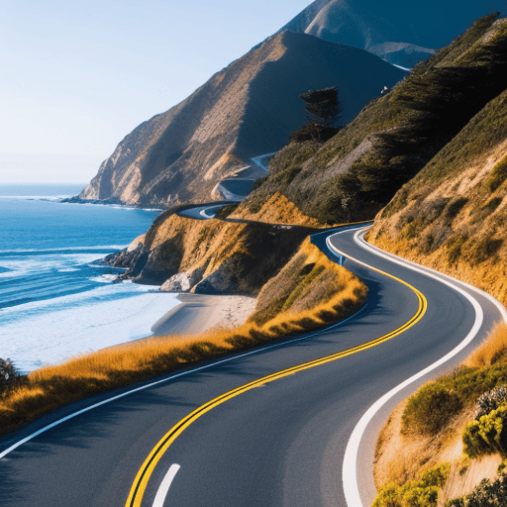 Picture of a winding road along the Pacific Coast Highway, with a beach in the background